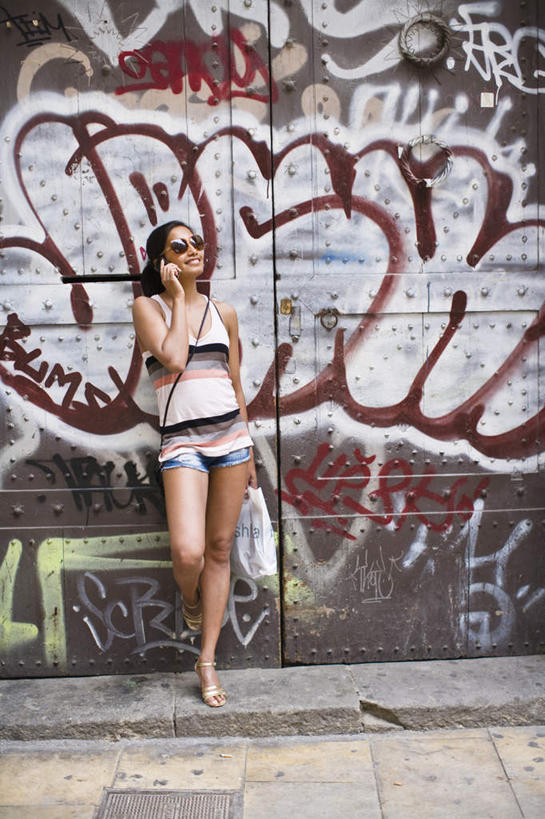 西方人,腿部,腿,一个人,站,举,笑,打电话,微笑,露齿笑,竖图,彩色,室外,白天,正面,购物,旅游,度假,消费,袋子,电话,手机,金属制品,欧洲,欧洲人,仅一个年轻女性,仅一个女性,仅一个人,握,服装,金属,英文,包,包装袋,标志,瓷砖,地砖,墨镜,皮包,手提袋,文字,眼镜,字符,字母,墙,购物袋,地面,拿,拎,拿着,休闲装,娱乐,通讯设备,标识,墙壁,墙面,衣服,太阳镜,太阳眼镜,托,站着,享受,休闲,休闲服,遮阳镜,放松,提,握着,金融,服饰,英文字母,单肩包,杂乱,混乱,提着,购买,蜷曲,贸易,紊乱,芜杂,交流,年轻女性,女人,女性,白种人,沟通,举起,举手,举着,抬头,通话,向上举,向上伸,向上托,仰头,站立,彩图,全身,涂鸦,拎着