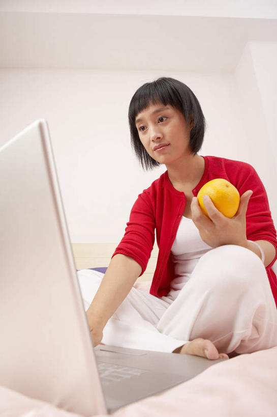 一个人,坐,竖图,室内,正面,仰视,笔记本电脑,互联网,床,水果,北京,中国,亚洲,打字,看,放松,乐趣,摄影,专心,享乐,搜寻,年轻女性,中国人,桔子,触摸,彩图,低角度拍摄
