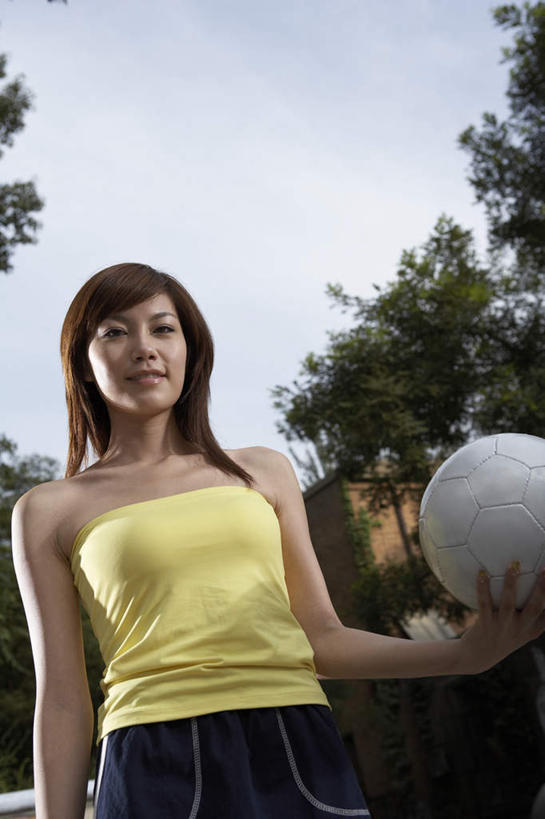 一个人,站,微笑,竖图,室外,留白,正面,仰视,裙子,橄榄球,北京,中国,亚洲,球门,足球运动员,T恤,夏天,看,休闲,放松,活力,摄影,生长,专心,享乐,体育器械,肖像,田径运动,足球运动,年轻女性,中国人,年轻人,彩图,低角度拍摄,精力