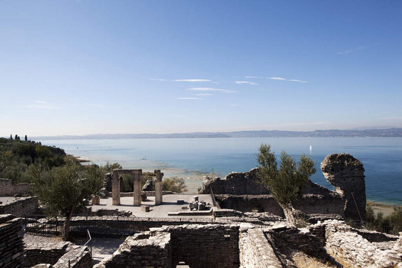 无人,横图,俯视,室外,白天,旅游,度假,湖,湖泊,石头,名胜古迹,水,植物,标志建筑,地标,建筑,意大利,欧洲,阴影,遗迹,光线,石子,影子,柱子,墙,湖面,水流,水面,水平线,云,云朵,辽阔,云彩,古迹,文物,娱乐,建设,古建筑,墙壁,墙面,树,树木,蓝色,绿色,白云,蓝天,天空,阳光,自然,湖水,天,享受,休闲,广阔,旅游胜地,放松,生长,晴朗,成长,一望无际,南欧,古文明,意大利共和国,无边无际,一马平川,布雷西亚省,贝纳科湖,加尔达湖,石块,岩石,晴空,彩图,高角度拍摄,水天相接,水天一线