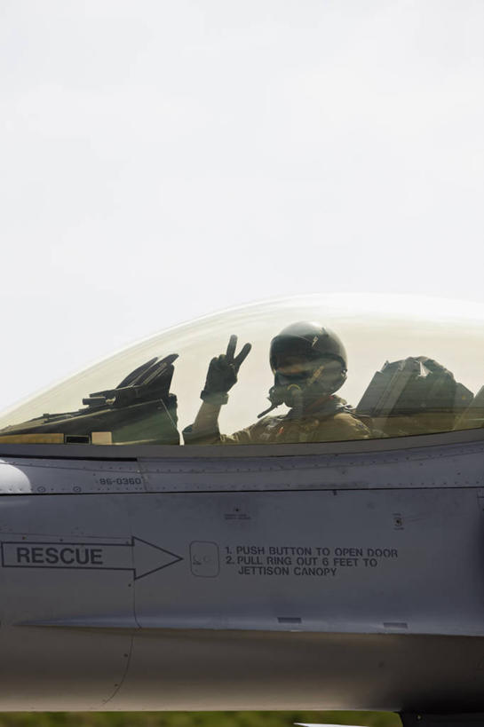 成年人,一个人,飞行员,竖图,室外,白天,侧面,安全,美国,仅一个男性,力量,战争,摄影,空军,幽默,准确,打斗,进攻,反差,军用机,座舱,科罗拉多州,F-16战隼战斗机,蝰蛇,技能,男人,彩图,反话,和平手势