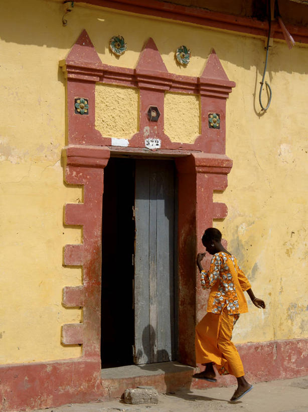 西方人,一个人,家,走,竖图,室外,白天,侧面,旅游,度假,名胜古迹,门,标志建筑,地标,建筑,欧洲,非洲,塞内加尔,黑人,欧洲人,仅一个女性,仅一个人,服装,遗迹,房屋,墙,屋子,古迹,文物,娱乐,建设,古建筑,楼房,墙壁,墙面,住宅,衣服,黄色,门框,仅一个中年女性,享受,休闲,旅游胜地,放松,服饰,衣着,穿着,古文明,首府,衣饰,塞内加尔共和国,西非,圣路易,女人,女性,中年女性,非洲人,步行,散步,走路,彩图,全身,房子,圣路易区