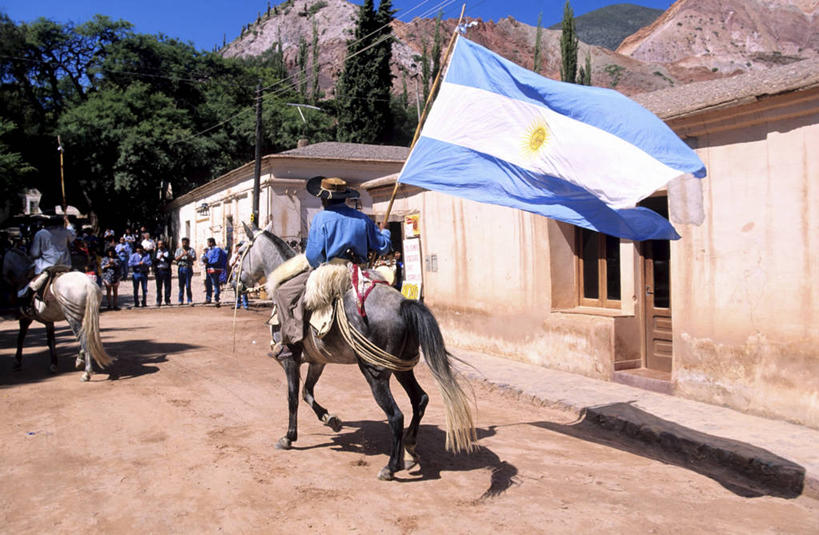 西方人,家,走,横图,室外,白天,度假,美景,太阳,植物,城市风光,城市,道路,路,马,野生动物,旗帜,国旗,帽子,阿根廷,欧洲,欧洲人,一面,行人,游客,游人,骑马,握,阴影,服装,光线,影子,房屋,墙,屋子,景观,小路,交通,许多人,休闲装,娱乐,楼房,路人,旅客,墙壁,墙面,住宅,树,树木,骑,背面,衣服,黄色,蓝色,绿色,白色,灰色,蓝天,天空,阳光,自然,动物,遮阳帽,天,两只,一群人,享受,休闲,休闲服,景色,南美,放松,握着,运输,服饰,牲畜,生长,晴朗,成长,南美洲,拉丁美洲,美洲,万里无云,亚美利加洲,南亚美利加洲,阿根廷共和国,过客,男人,男性,年轻男性,白种人,旗,晴空,晴空万里,步行,散步,走路,彩图,全身,房子,阿根廷国旗,布宜诺斯艾利斯省