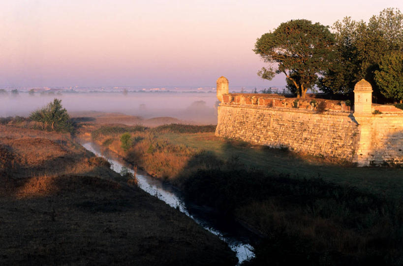 无人,横图,室外,白天,正面,旅游,度假,建材,草地,草坪,河流,名胜古迹,日落,水,植物,标志建筑,地标,建筑,法国,欧洲,遗迹,材料,砖,砖块,堡垒,城堡,墙,河水,水流,晚霞,霞光,落日,古迹,文物,娱乐,建设,古建筑,墙壁,墙面,草,树,树木,绿色,灰色,自然,黄昏,享受,休闲,砖头,旅游胜地,彩霞,放松,建造,生长,成长,西欧,要塞,法兰西,古文明,法兰西共和国,法兰西第五共和国,夕照,薄暮,普瓦图.夏朗德,普瓦图.夏朗德大区,设防,夏朗德省,石料,夕阳,彩图,傍晚,砌墙砖,罗什福尔区,耶尔布鲁阿格,斜阳