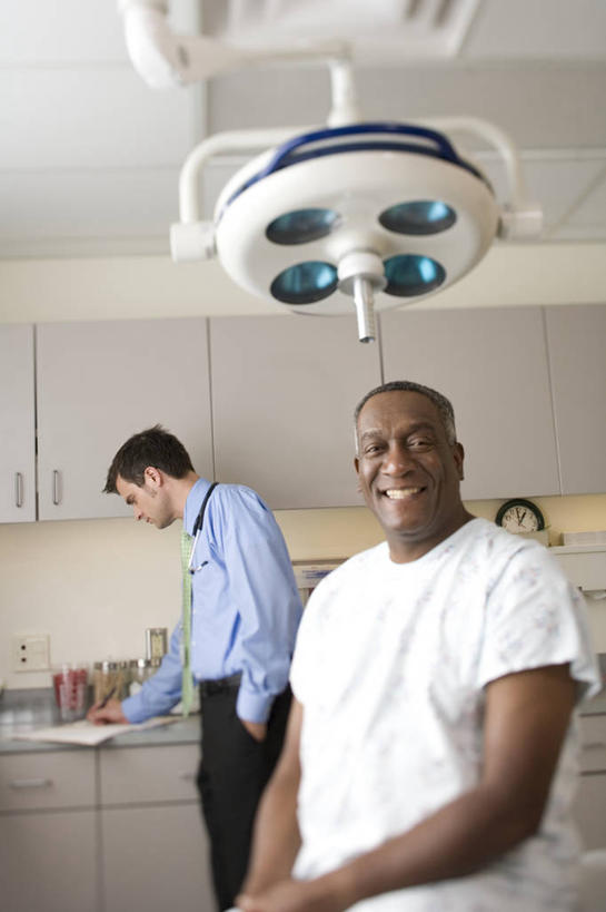 西方人,两个人,医生,病人,医院,站,坐,笑,微笑,露齿笑,竖图,室内,白天,正面,西装,柜子,照明,欧洲,非洲,黑人,欧洲人,套装,服装,正装,灯光,储物柜,注视,休闲装,职业装,灯,衣服,灯具,观察,看,站着,医护人员,医疗人员,休闲,休闲服,服饰,观看,照亮,察看,手术灯,照明设备,储存,关注,医疗机构,储备,蕴藏,贮备,男人,男性,中年男性,白种人,非洲人,大夫,患者,就医者,站立,坐着,半身,彩图,病院,诊所,贮存