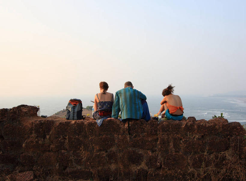 成年人,三个人,坐,横图,室外,白天,旅游,度假,印度,行人,游客,游人,围墙,石墙,路人,旅客,背面,放松,摄影,享乐,果阿,过客,男人,女人,彩图,旅行