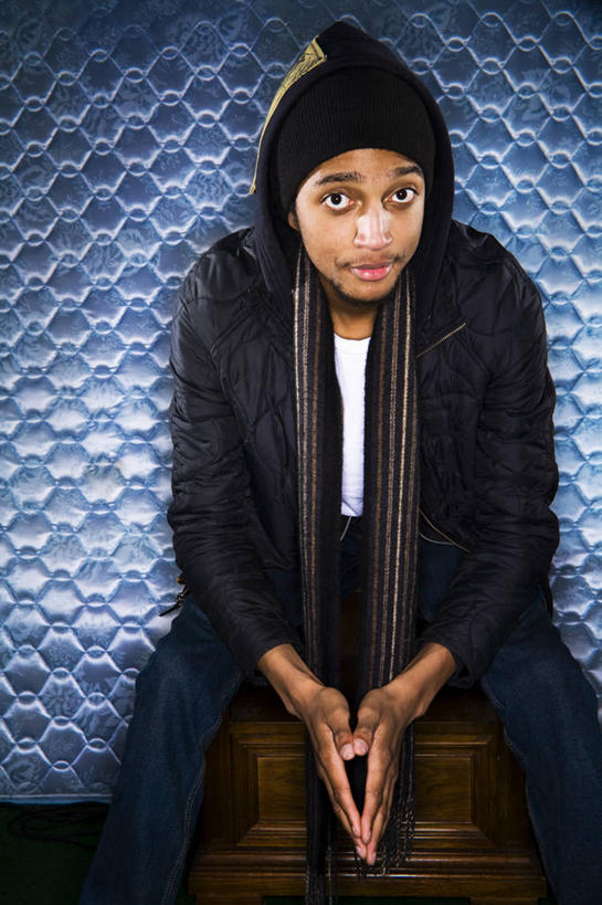 成年人,一个人,坐,竖图,室内,正面,时尚,帽子,美国,仅一个男性,仅一个人,服装,休闲装,外套,仅一个年轻男性,衣服,黑色,围巾,休闲,休闲服,连帽衫,个性,摄影,服饰,录音棚,毛发,嘻哈,肖像,帽衫,编织帽,男人,男性,年轻男性,非洲人,年轻人,彩图