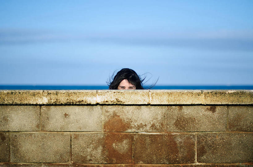 西方人,成年人,头,头发,一个人,横图,室外,白天,西班牙,欧洲,欧洲人,仅一个年轻女性,仅一个女性,仅一个人,云,围墙,顶部,黑色,天空,人体,摄影,部分,隐藏,肖像,年轻女性,女人,女性,白种人,年轻人,头部,彩图,窥视,乱发,好奇心