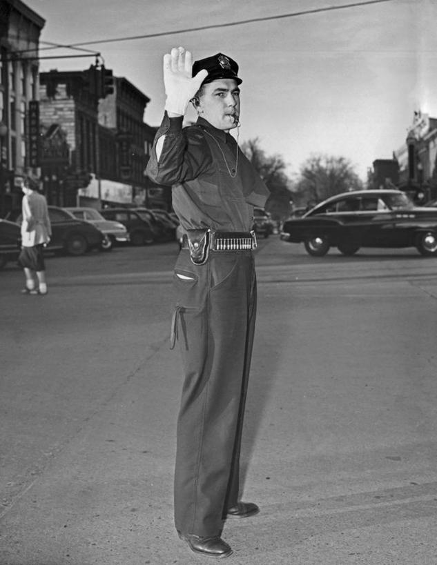 西方人,成年人,中年人,老年人,一个人,交警,竖图,黑白,室外,白天,安全,城市,建筑,路,汽车,欧洲,欧洲人,陆地,交通,方向,车,树,天空,手套,交通工具,手势,发动机,鸭舌帽,力量,运输,摄影,建造,指导,权威,口哨,载具,警官,警服,责任,老年男性,男人,中年男性,白种人,交通管理员,交通警察,打手势,法律