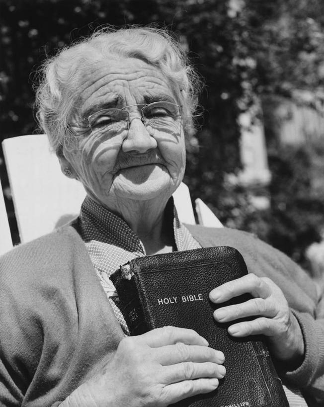 西方人,成年人,老年人,皱纹,头发,一个人,微笑,竖图,黑白,室外,特写,白天,日光,欧洲,欧洲人,仅一个女性,眼镜,圣经,休闲装,白色,摄影,宗教,基督教,食品加工厂,灵性,老年女性,女人,女性,白种人,书,半身,对焦