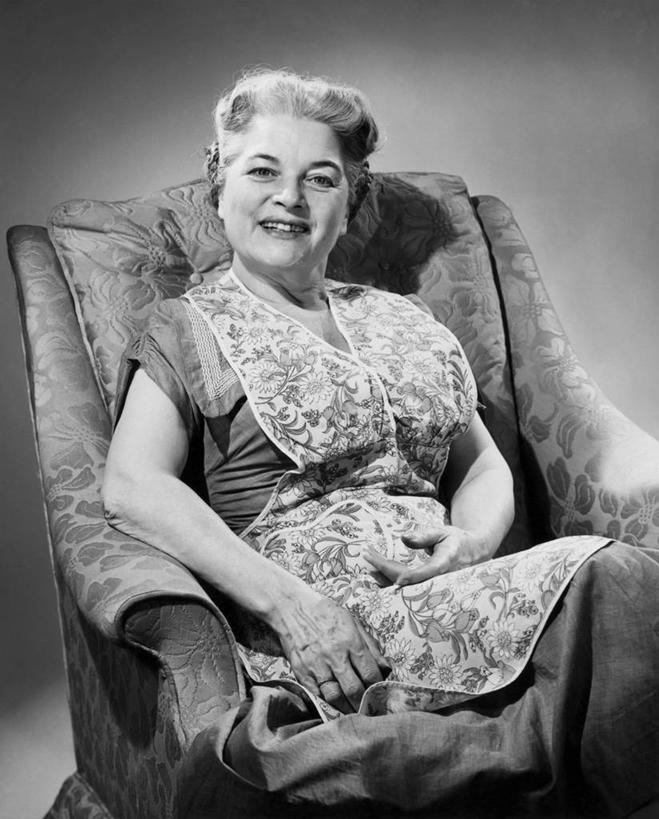 西方人,成年人,老年人,头发,一个人,坐,微笑,竖图,黑白,室内,快乐,幸福,欧洲,欧洲人,仅一个女性,围裙,二郎腿,休闲装,放松,人体,摄影,矮,退休,扶手椅,肖像,软垫,老年女性,女人,女性,白种人,短发