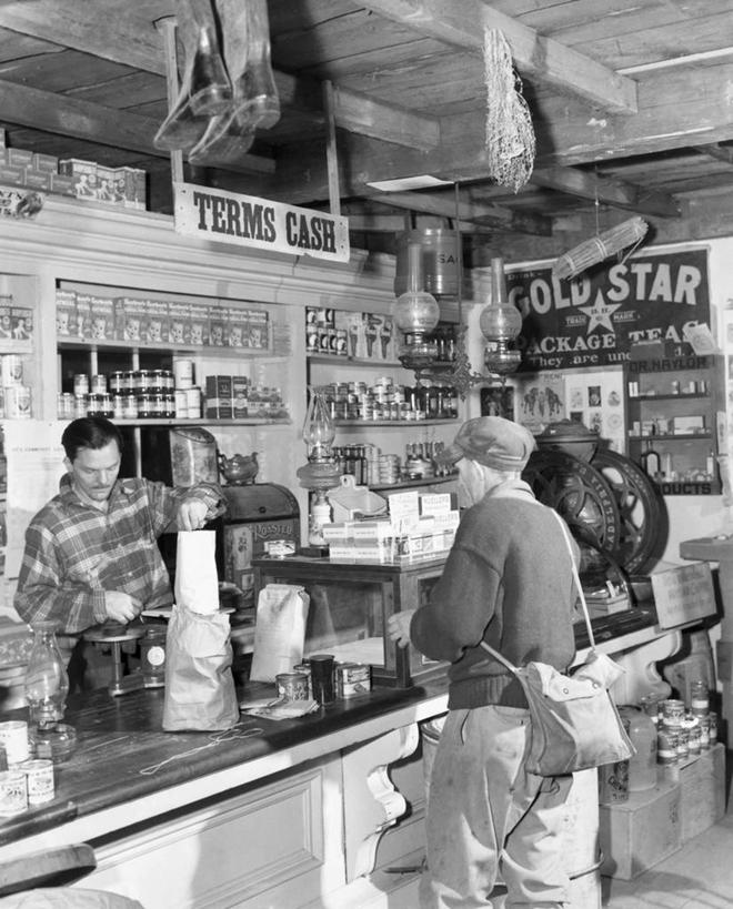 西方人,成年人,中年人,老年人,两个人,商店,竖图,黑白,室内,购物,消费,欧洲,欧洲人,包,商品,购物袋,顾客,架子,鸭舌帽,零售,摄影,收银台,购买,运送,贩卖,广口瓶,老年男性,男人,男性,白种人,售货员