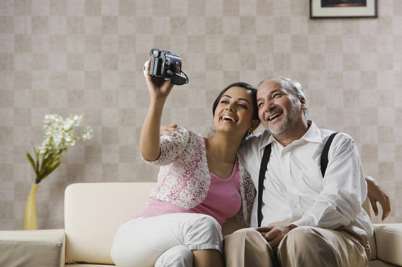 成年人,中年人,老年人,两个人,家庭,父亲,女儿,坐,举,微笑,横图,室内,白天,幸福,技术,沙发,花瓶,印度,连接,首都,休闲装,相视,花束,温暖,温馨,一家人,面对面,放松,自拍,摄影,对视,和睦,起居室,互视,相对,相看,新德里,老年男性,男性,年轻女性,女性,印度人,年轻人,彩图,融洽,数码摄像机