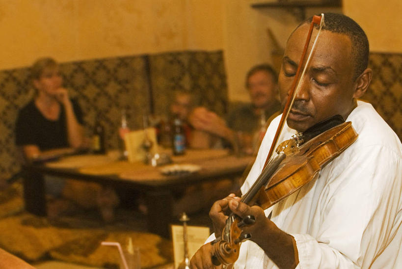 一个人,横图,室内,吃饭,旅游,非洲,坦桑尼亚,行人,游客,游人,岛,乐器,小提琴,热,音乐,路人,旅客,摄影,种族,音乐人,东非,桑吉巴尔,过客,海滩,休闲活动,彩图,餐馆,传统文化,季候风