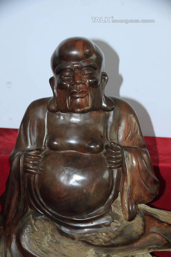 东方人,一个人,无人,和尚,坐,举,笑,微笑,竖图,室内,白天,正面,静物,雕塑,亚洲,仅一个男性,仅一个人,仅一个中年男性,阴影,节日,艺术,装饰,光线,光泽,木制,雕刻,雕像,佛像,影子,墙,棕色,织物,光芒,黄种人,文化,墙壁,墙面,红色,白色,阳光,木制品,工艺品,祈祷,托,健康,展示,许愿,宗教,根雕,佛教,信仰,纪念,展览,支撑,祈求,美术,主题,陈列,罗汉,功能,美学,释教,阿罗汉,开心罗汉,十八罗汉,戍博迦,戍博迦尊者,绒布,平安,男人,男性,中年男性,亚洲人,比丘,高僧,僧,僧侣,僧人,沙弥,修行僧,举起,举手,举着,向上举,向上伸,向上托,坐着,半身,彩图,rzwdb1