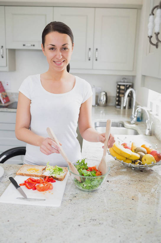 西方人,一个人,站,笑,微笑,露齿笑,竖图,室内,白天,正面,烹饪,西餐,厨房,柜子,桌面,桌子,蔬菜,玻璃,金属制品,欧洲,欧洲人,仅一个年轻女性,仅一个女性,仅一个人,握,服装,新鲜,金属,工具,水槽,水龙头,调料,酱料,酱汁,蔬菜沙拉,佐料,沙拉,料理,食品,案板,刀具,调味品,储物柜,拿,调味料,拿着,注视,休闲装,色拉,水斗,酱,沙拉酱,沙律,菜肴,美食,开关,玻璃制品,砧板,食物,衣服,容器,碗,刀,打开,观察,看,站着,休闲,休闲服,西式,握着,服饰,佳肴,有机食品,绿色食品,观看,色拉酱,储藏,阀门,察看,开启,储存,关注,菜刀,切菜刀,水咀,储备,蕴藏,贮备,年轻女性,女人,女性,白种人,站立,半身,彩图,灶间,厨房料理台,贮存,料理台