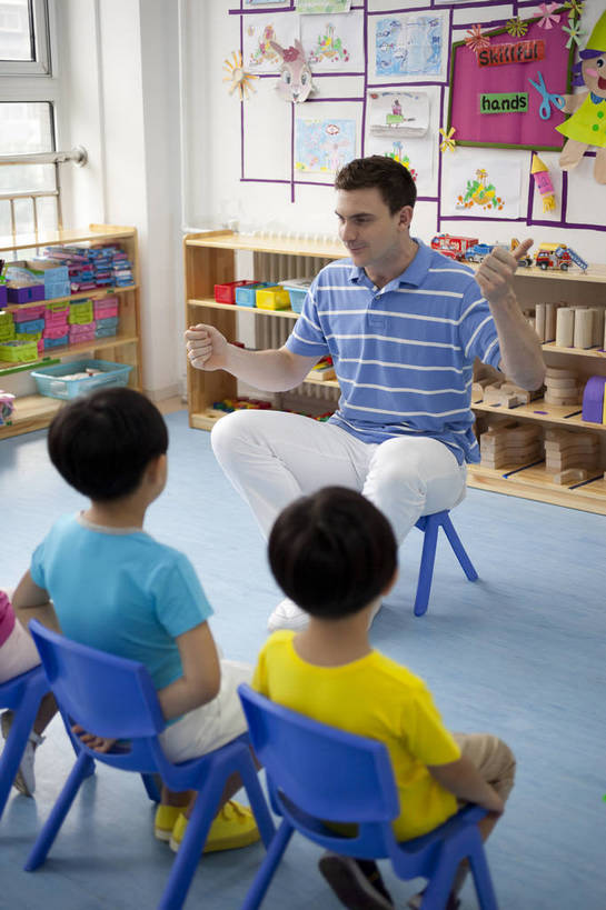 东方人,西方人,婴儿,儿童,中年人,三个人,伙伴,教师,坐,竖图,彩色,室内,白天,侧面,快乐,友谊,幸福,纯洁,合作,柜子,玩具,北京,中国,欧洲人,板凳,图片,教育,小孩,小女孩,背面,背景墙,手势,教室,放松,可爱,童年,童趣,比划,讲解,外教,幼儿园,摄影,活泼,成长,希望,好奇,未来,学前教育,同伴,宝宝,纯真,烂漫,无邪,听讲,乐观,卡通画,伶俐,认真,天真,友情,男孩,男人,男性,年轻男性,美国人,亚洲人,中国人,孩子,年轻人,全身,男生,师生,bj174