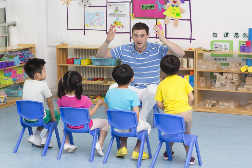 东方人,西方人,婴儿,儿童,中年人,伙伴,教师,坐,横图,彩色,室内,白天,正面,快乐,友谊,幸福,纯洁,合作,柜子,玩具,北京,中国,欧洲人,五个人,图片,许多人,教育,听,小孩,小女孩,背面,背景墙,一群人,教室,放松,可爱,童年,童趣,比划,外教,幼儿园,摄影,活泼,成长,希望,好奇,未来,学前教育,同伴,宝宝,讲课,纯真,烂漫,无邪,乐观,卡通画,伶俐,认真,天真,友情,男孩,男人,男性,年轻男性,女人,女性,美国人,亚洲人,中国人,孩子,年轻人,全身,男生,师生,bj174